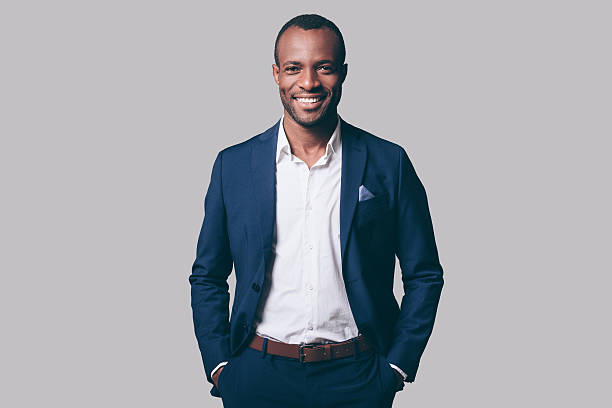 A Black man standiung in a blue suit. Glamour Magic