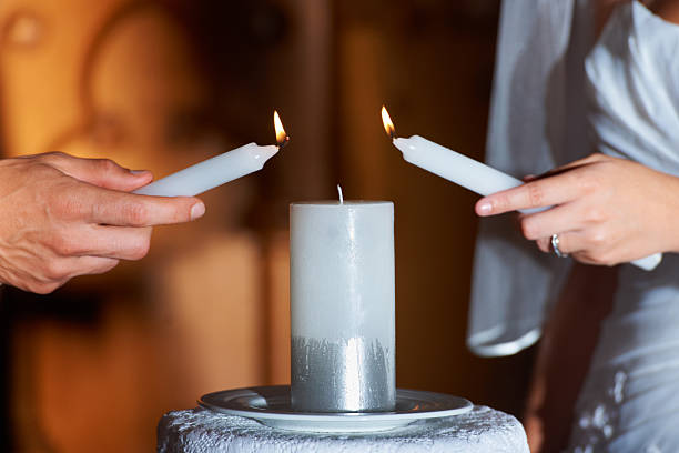 Two hands holding burning candles doing Divorce Spells Ritual