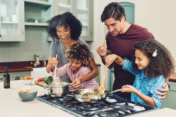 A Couple prepare food with their two kids. Love Spells in Nashville