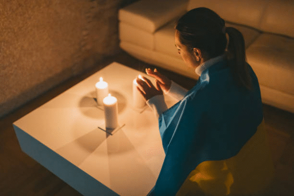 Woman performing candle ritual under full moon – best love spells that work at home