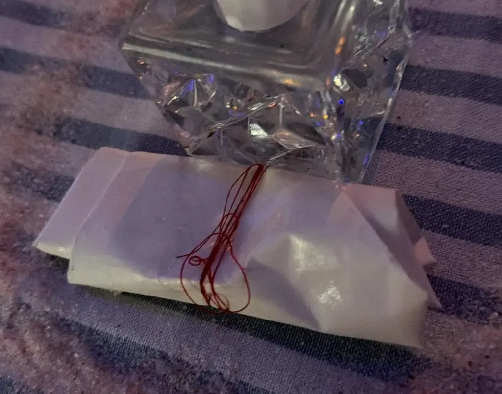 A folded petition paper inside a salt circle used during a return to sender spell