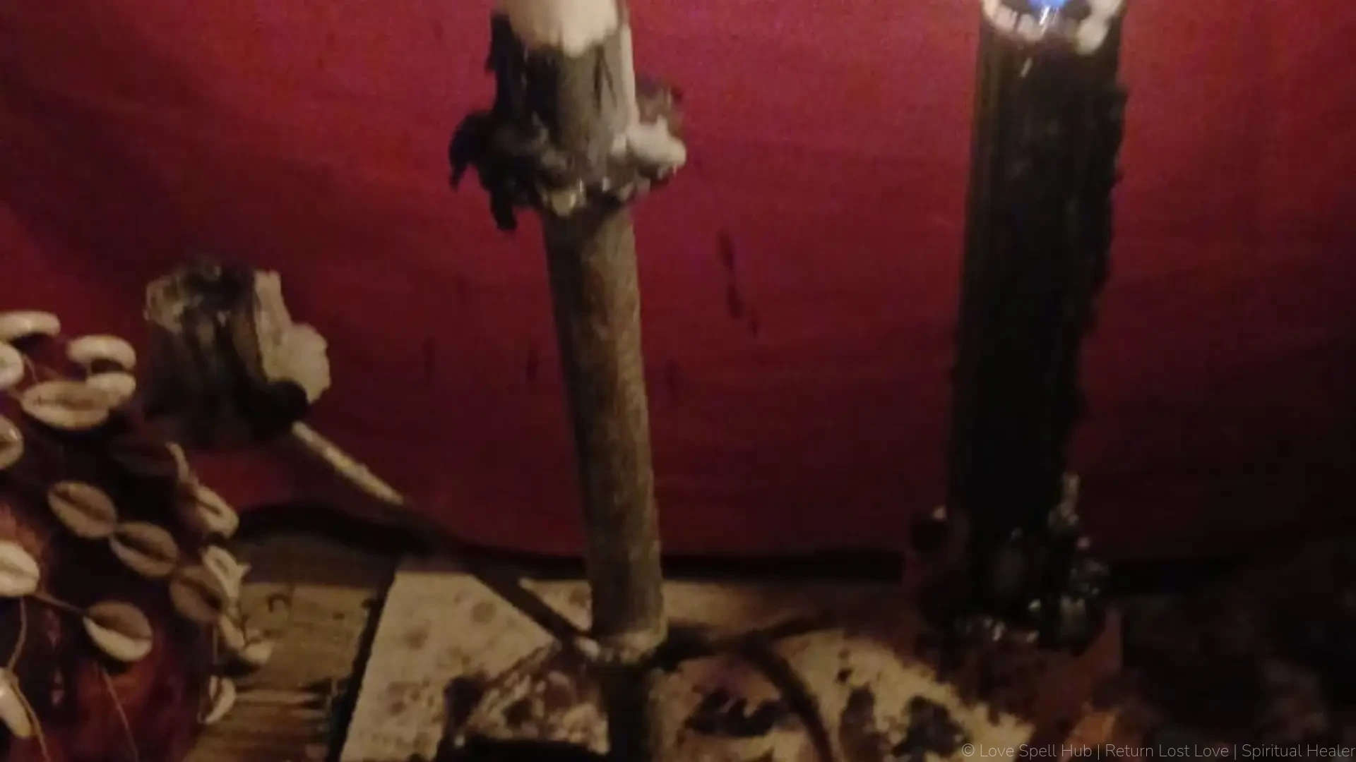 Healer Criss Batha traditional shrine altar with burning candles and cowrie shells for protection from evil spells