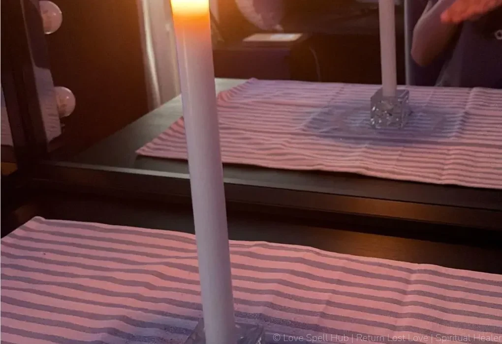 A burning white candle and defensive mirror work used for freezer spells